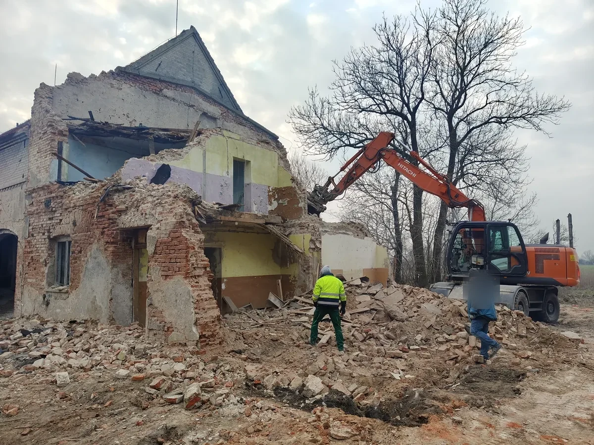 Rozbiórka starej zabudowy Rozbiórka starego murowanego domu z pracownikami przy gruzie