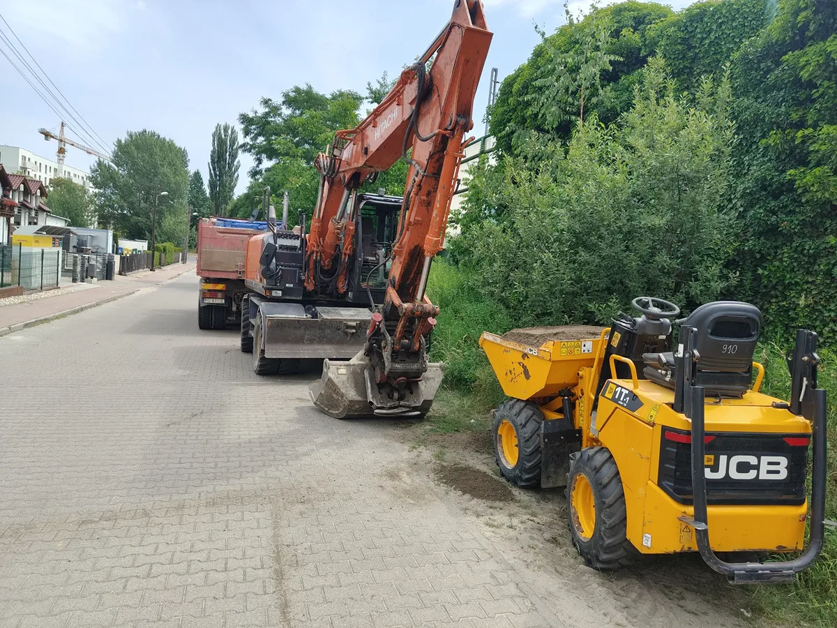 Sprzęt transportowy na placu Koparka i mini dumper JCB na ulicy podczas prac transportowych