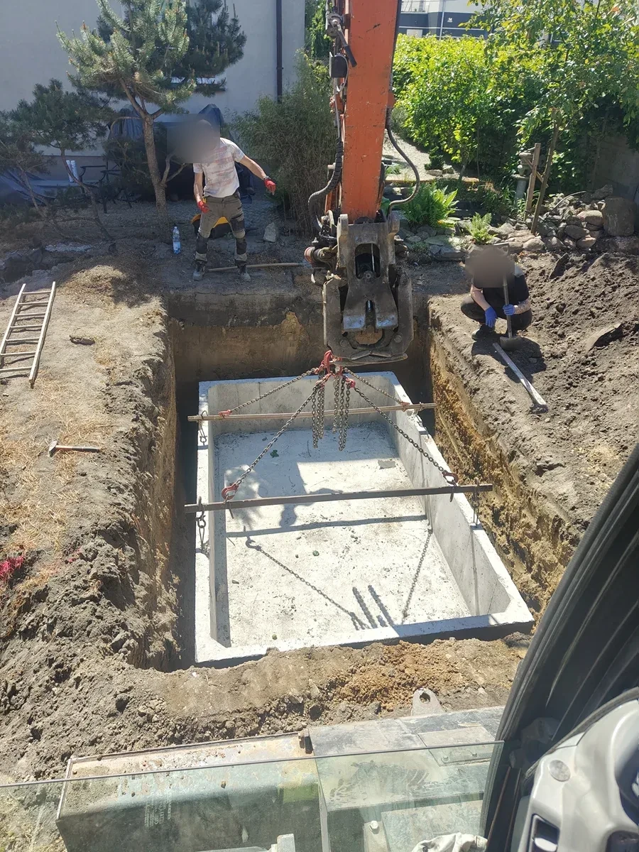 Osadzenie zbiornika w wykopie Prostokątny zbiornik betonowy z widocznym zbrojeniem osadzony w wykopie