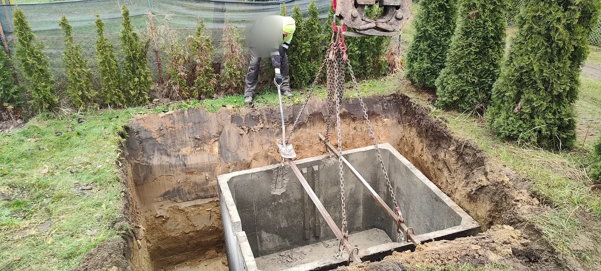 Montaż zbiornika dźwigiem Betonowy zbiornik opuszczany dźwigiem do przygotowanego wykopu