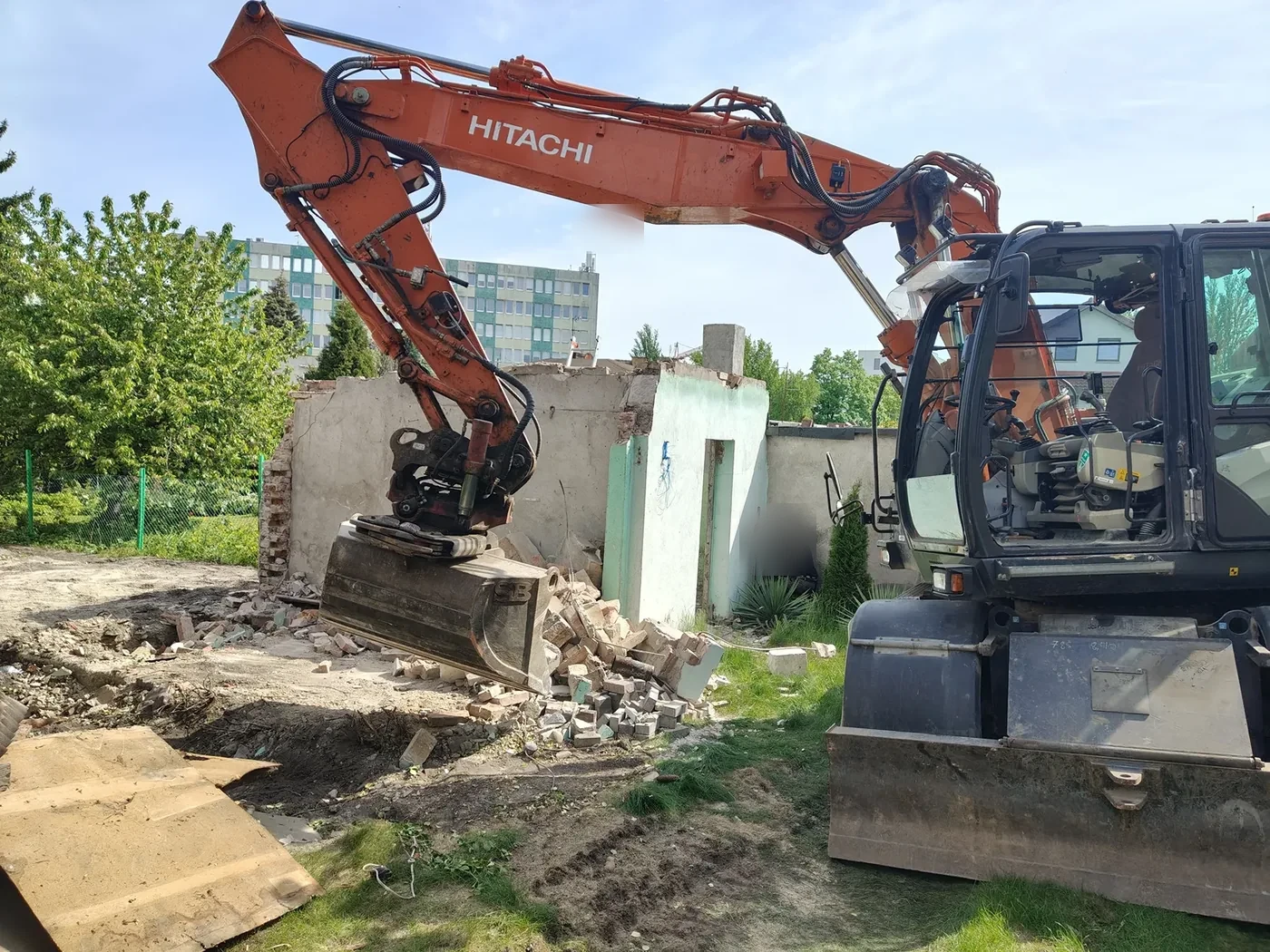 Kucie młotem hydraulicznym Koparka Hitachi z młotem hydraulicznym kruszy mur ceglany w ogrodzie